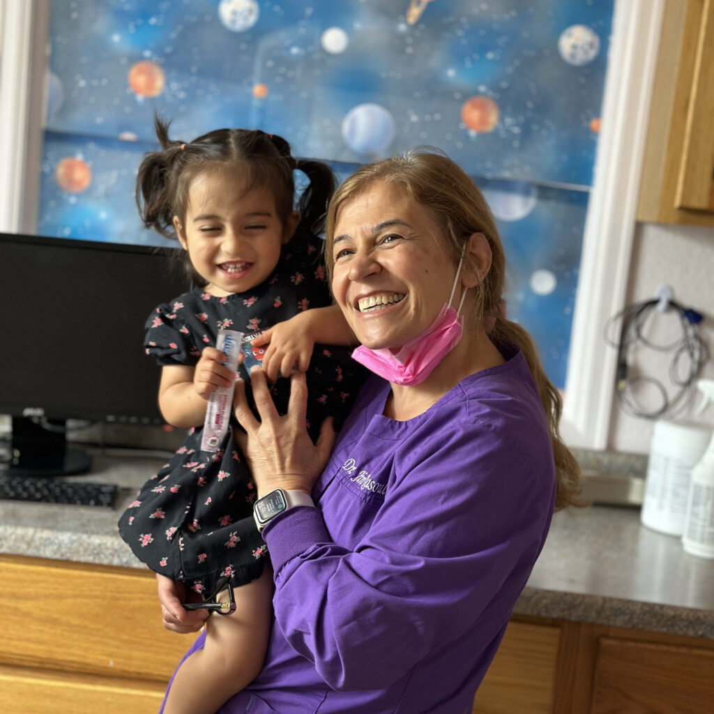 La Dra. Jina, dentista infantil en Denver, con un paciente